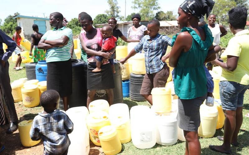 Community women fetch drilled and solar-pumped water at DESHAFO Integrated School