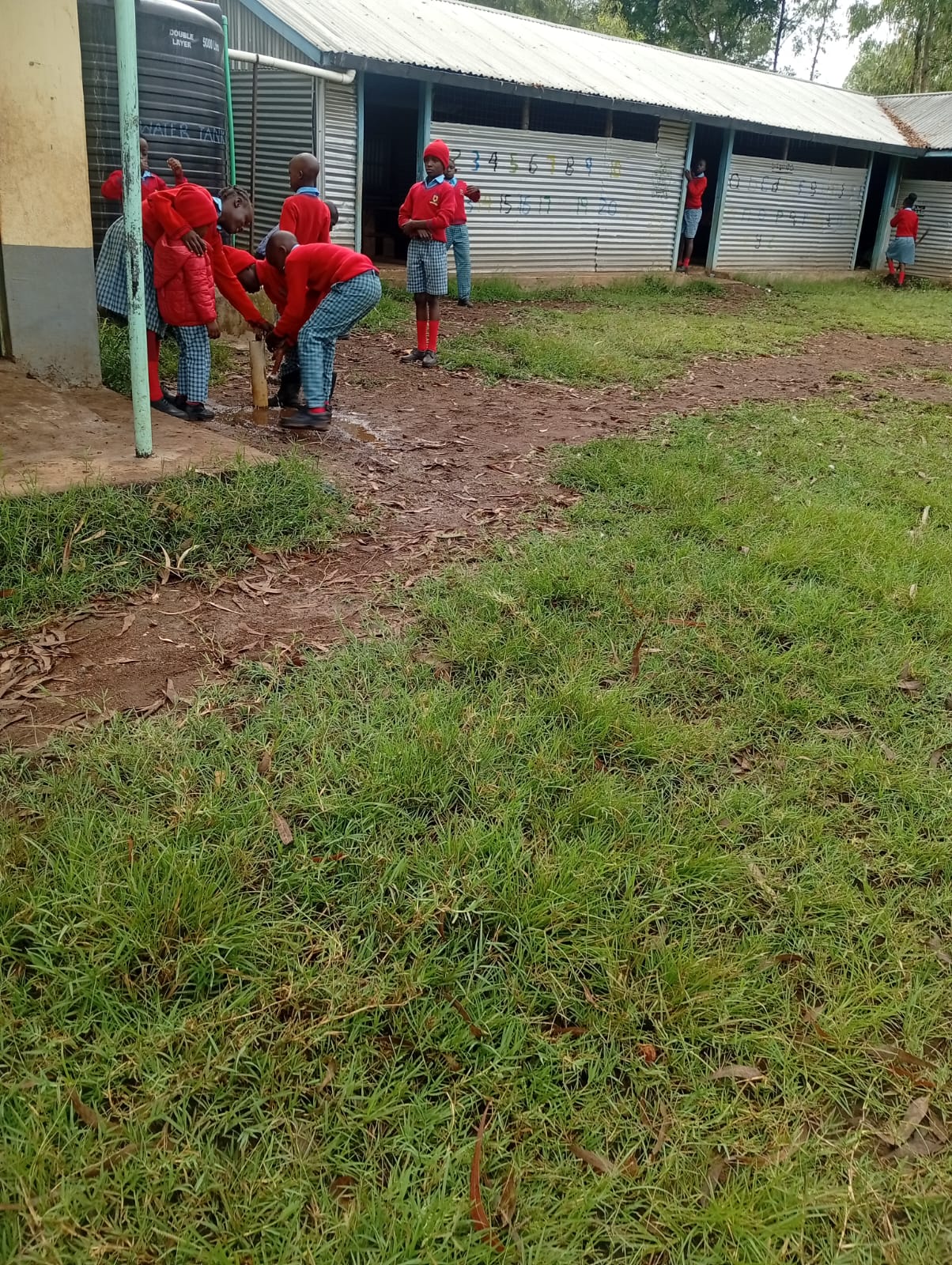 Learners practicing hygienic hand-washing with running water after environmental work